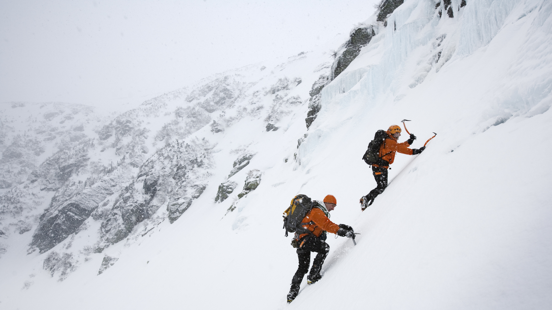 Dos personas escalando en hielo una montaña nevada