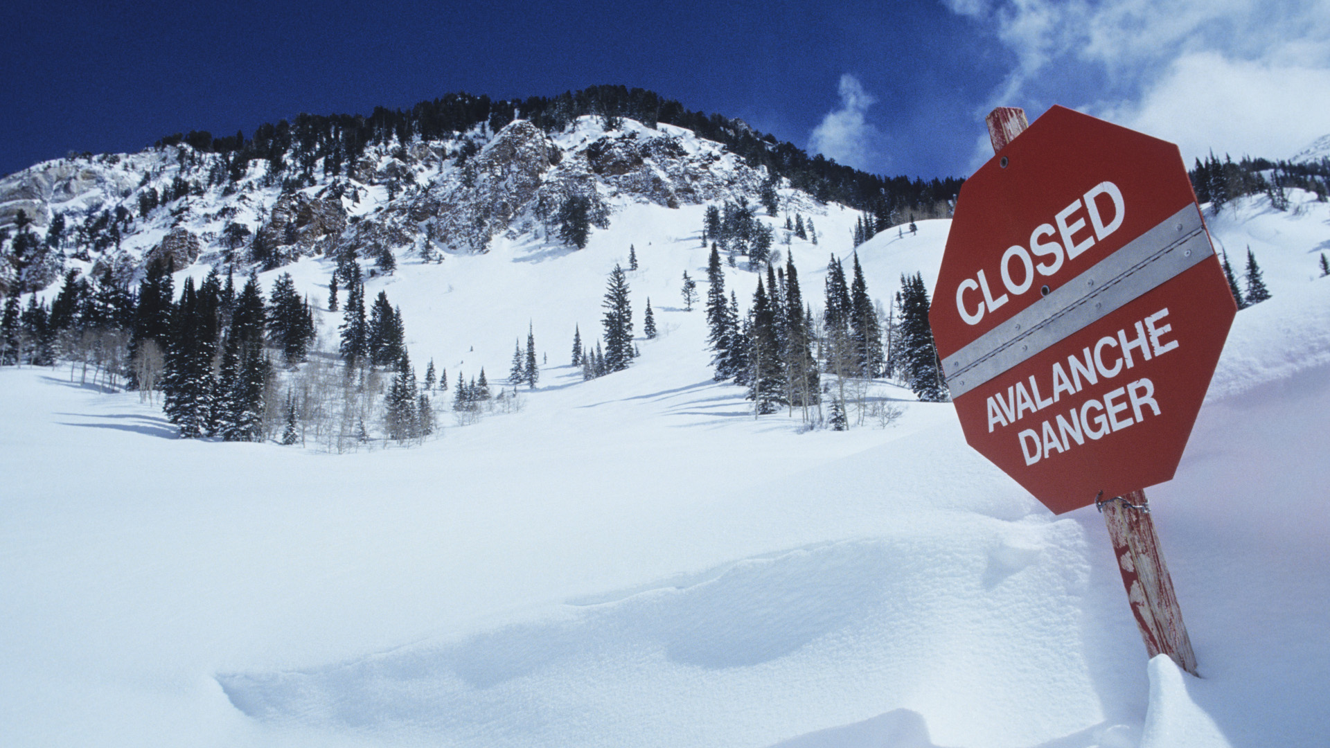 Una señal de peligro de avance en la nieve profunda en una estación de esquí