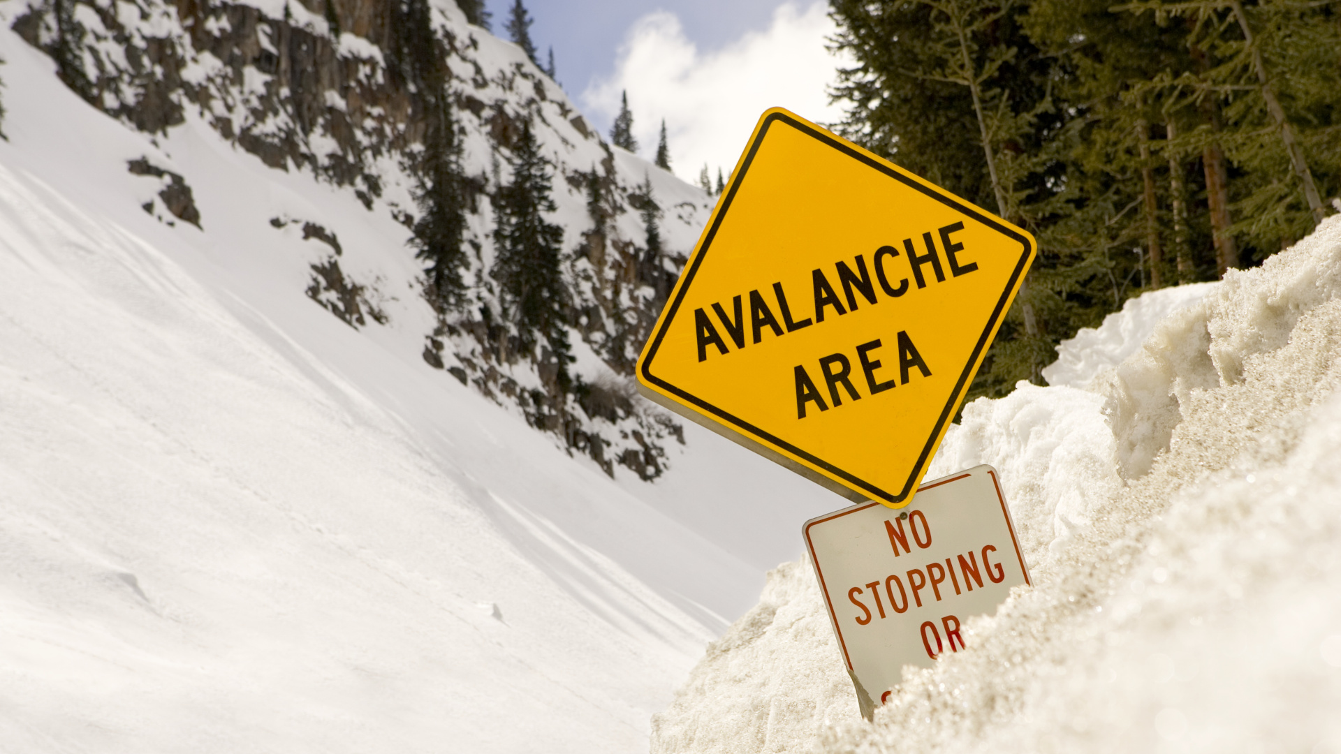 Una señal de advertencia de avalancha enterrada en la nieve profunda
