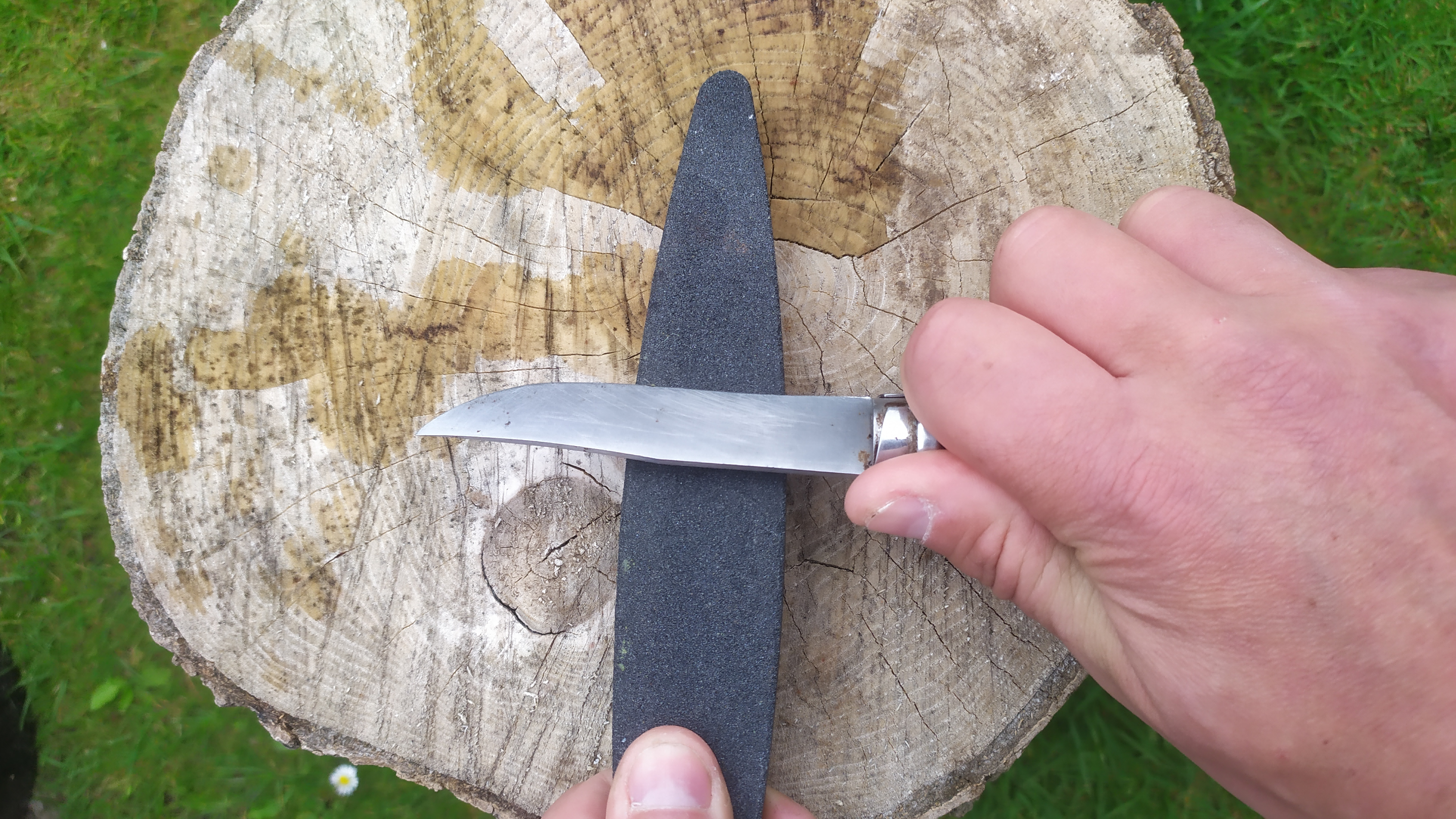 Demostración de cómo afilar un cuchillo de campamento en una piedra de afilar