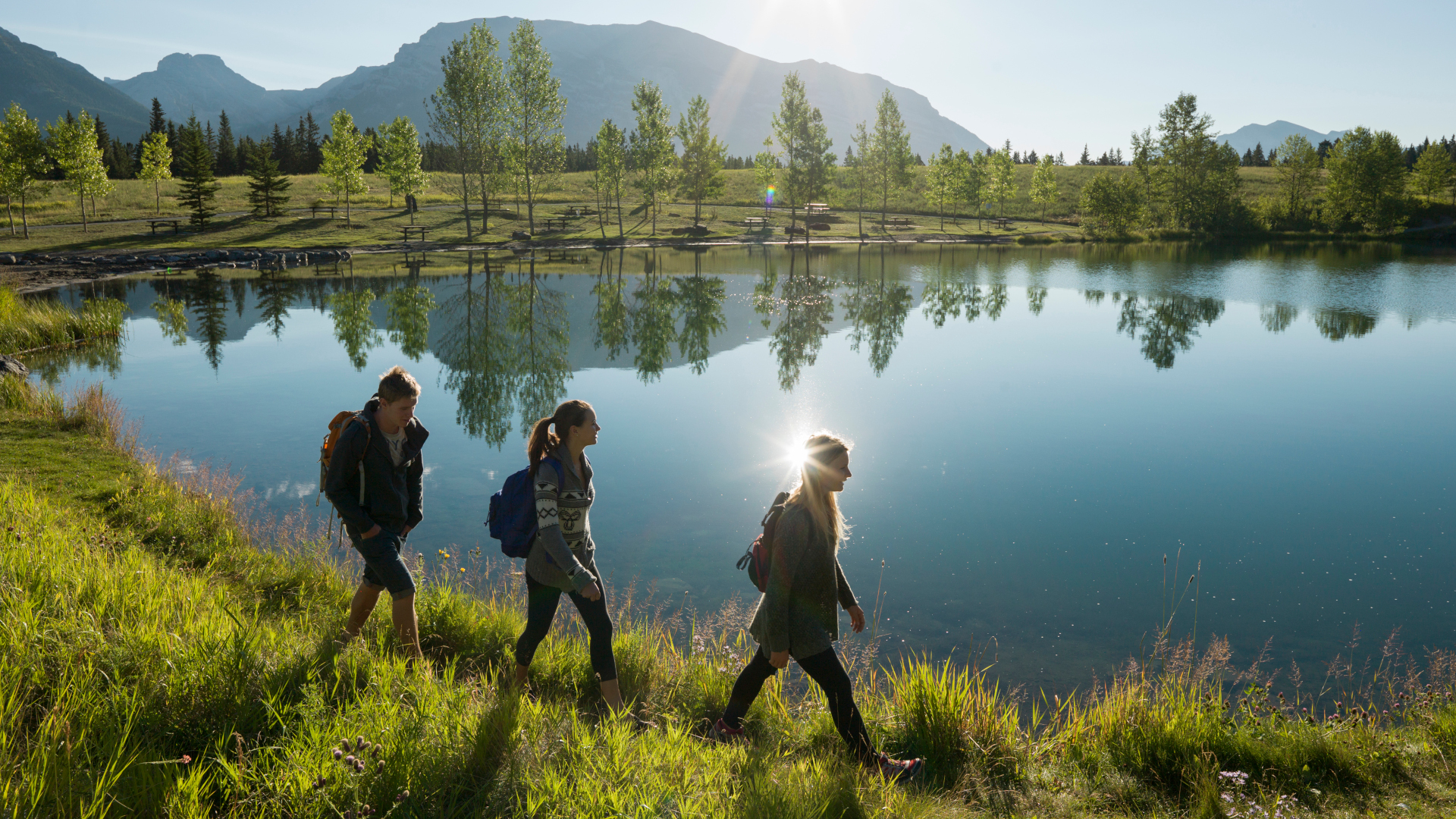 Tres excursionistas junto a un lago