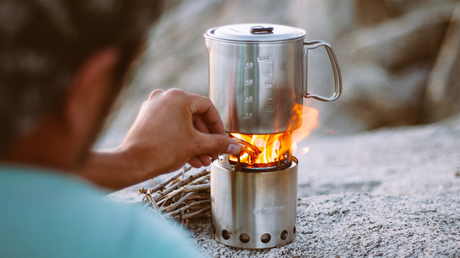 Un campista ajusta la llama de su estufa de camping
