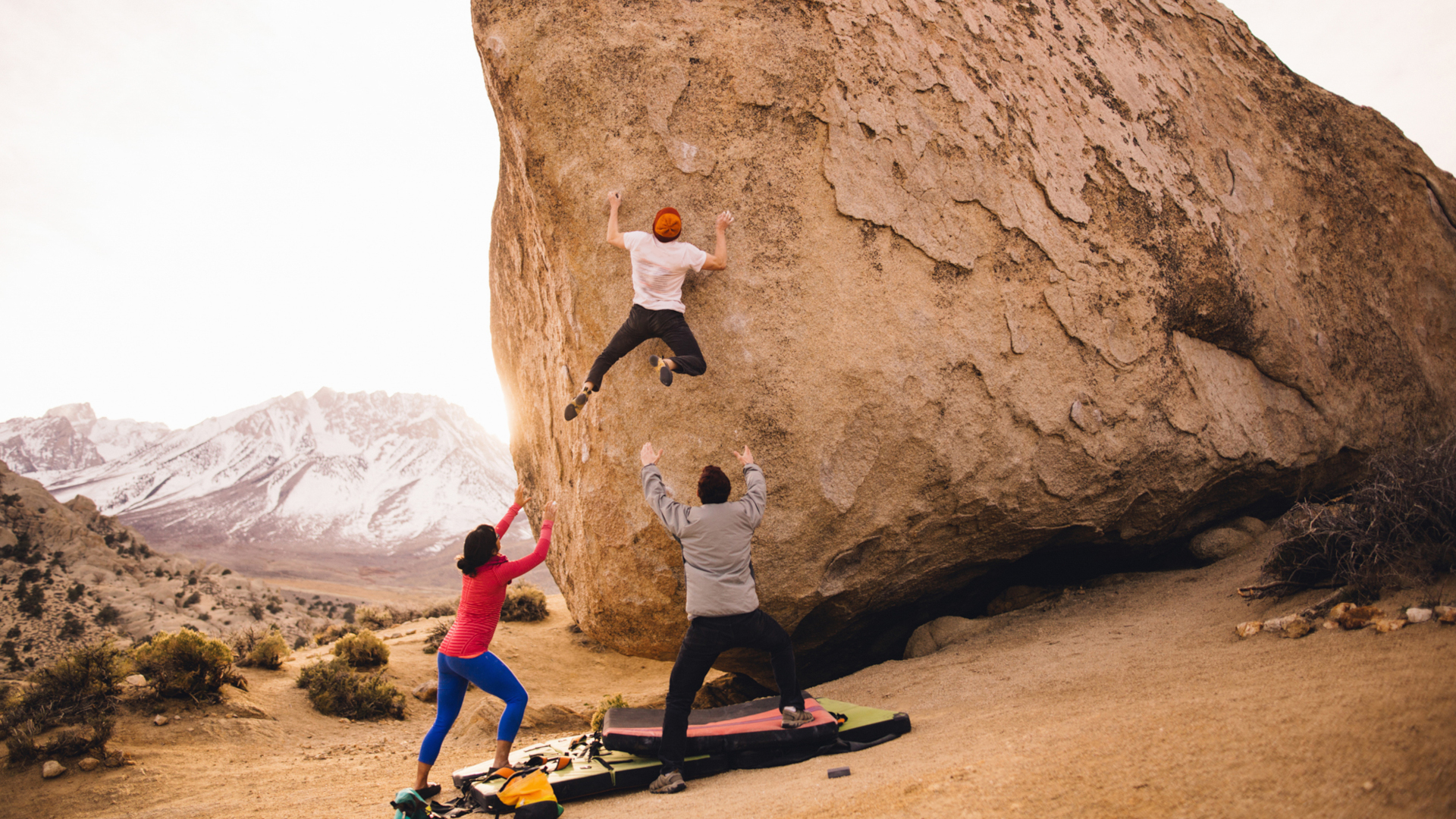 Tres amigos haciendo boulder juntos en el desierto