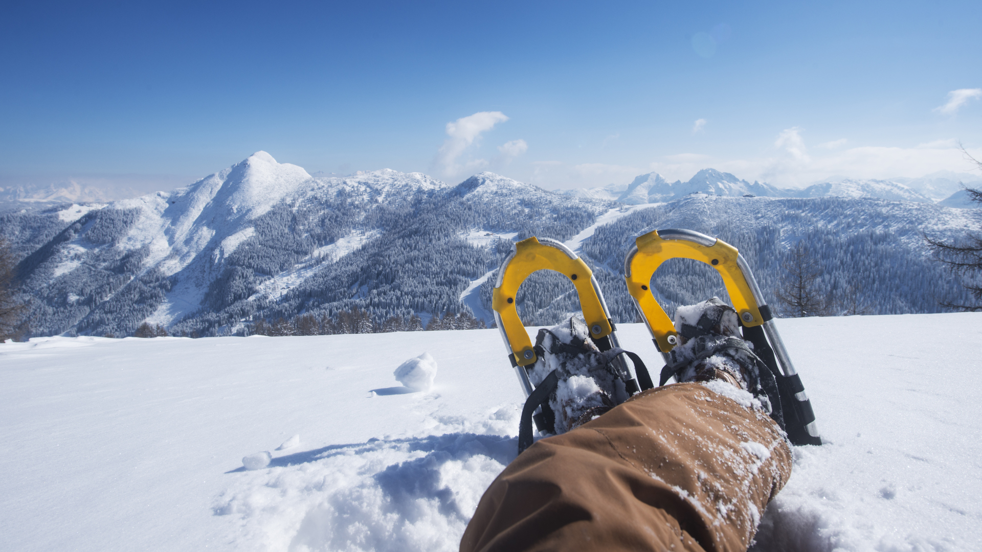 Imagen de las raquetas de nieve de un excursionista mientras se relaja y disfruta de las vistas a la montaña