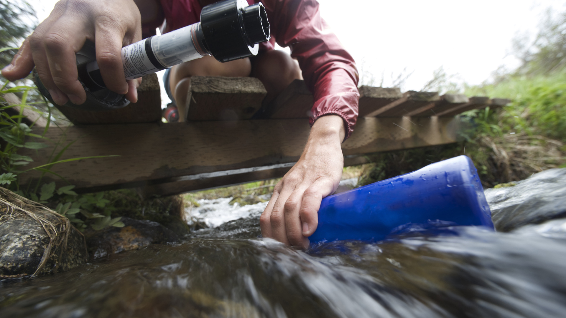 Un excursionista filtra el agua de un arroyo.