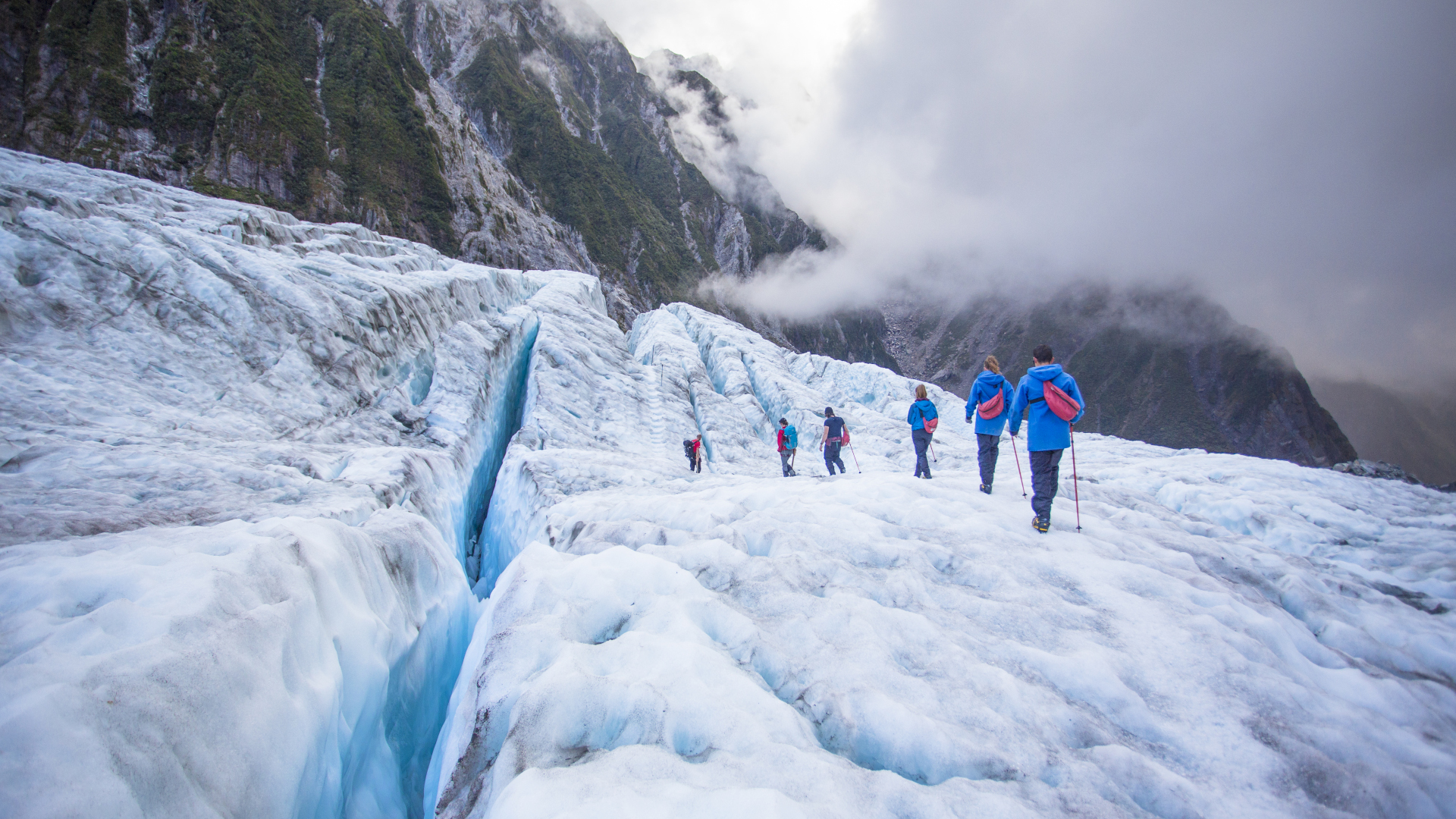 Un grupo cruza un glaciar atados con cuerdas