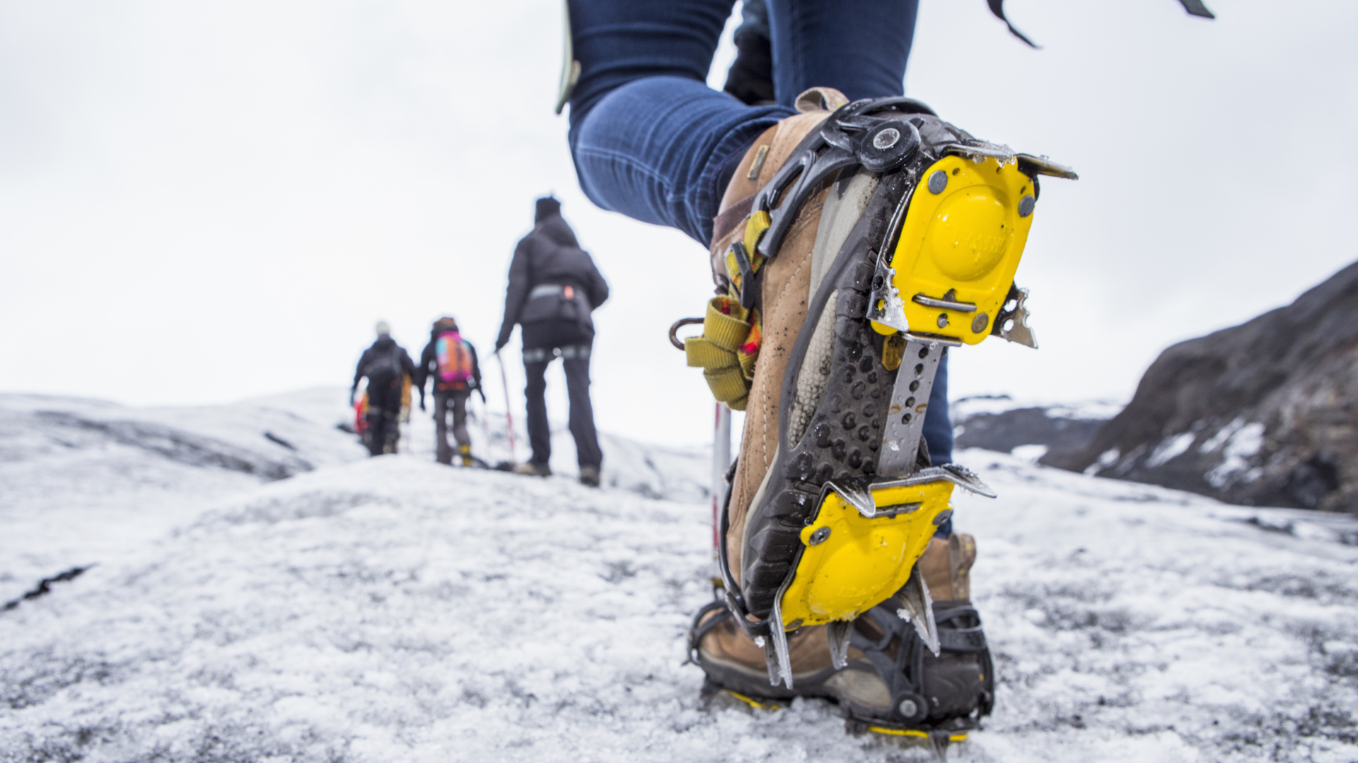 Excursionistas cruzando terreno helado con crampones