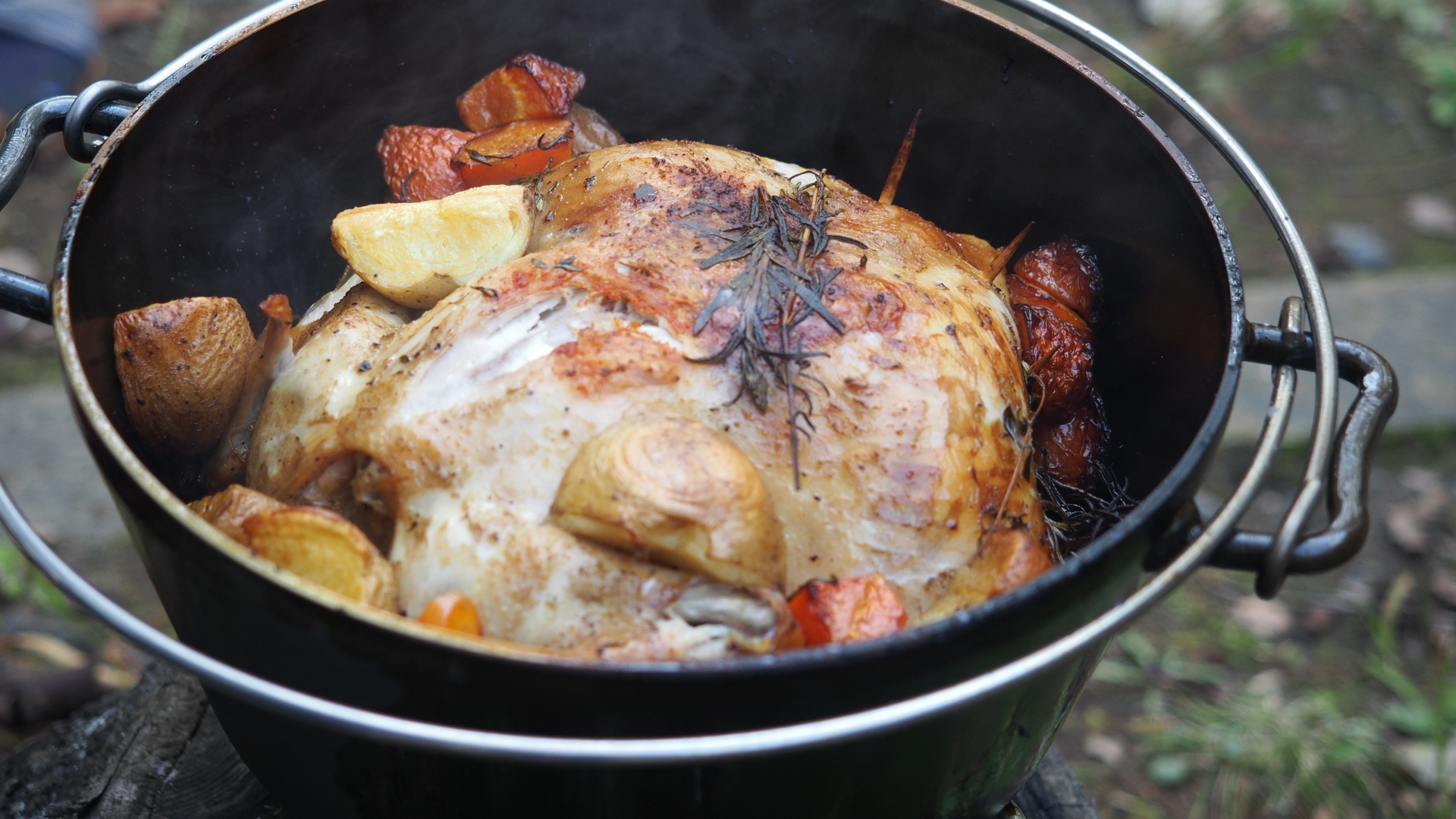 Un pollo entero cocinando en un horno holandés de camping
