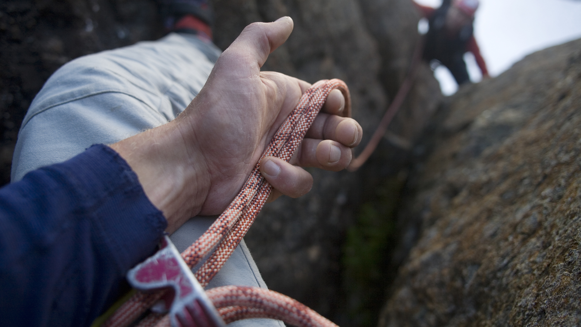 Cerca de las manos de un escalador asegurando compañero