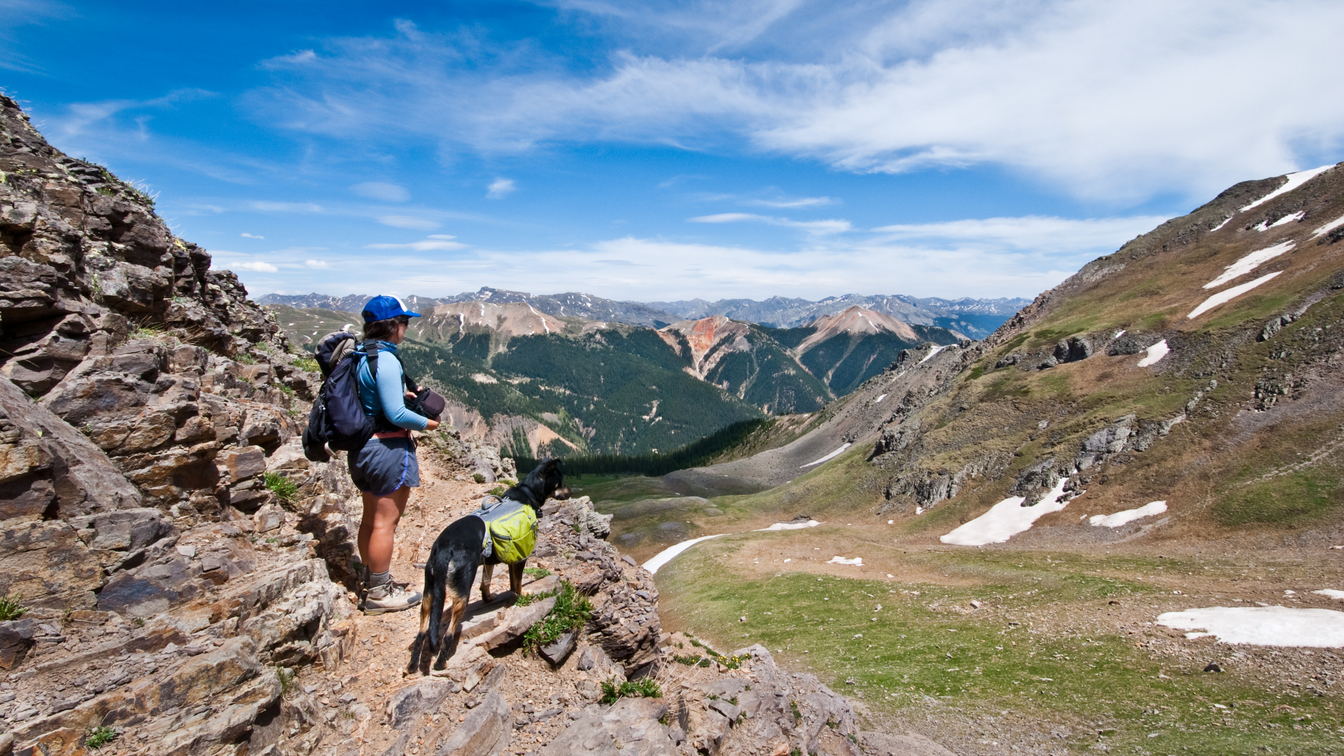 Una mujer y su perro caminando por las montañas de San Juan en Colorado